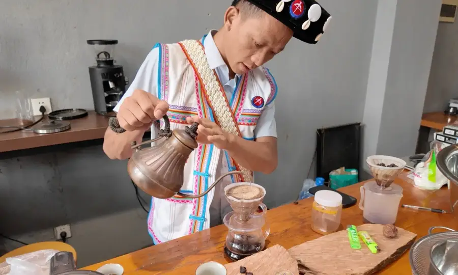 Local host in traditional dress brewing coffee