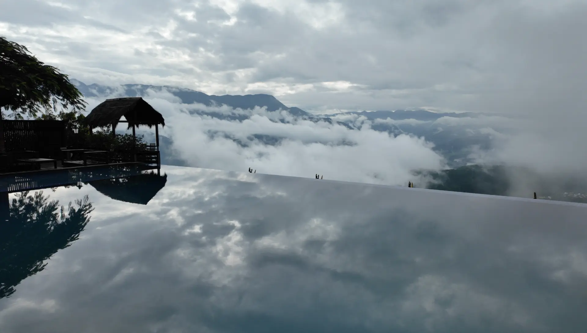 Infinity pool reflecting clouds and mountains