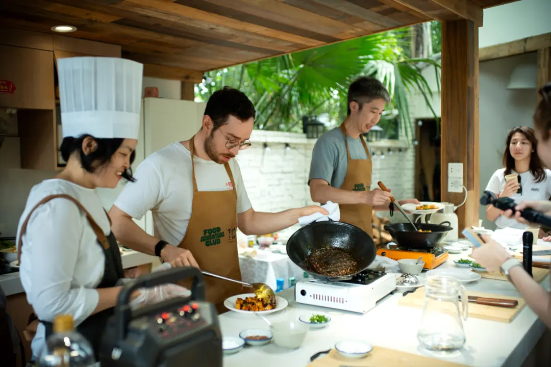 Guests cooking in woks at the cooking class