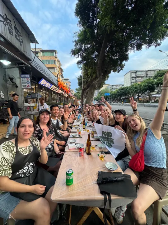 Outdoor farewell-style group meal on a Chengdu street